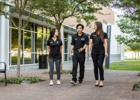 Three PharmD student walking on campus