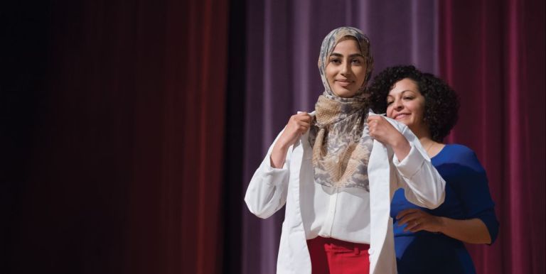 PharmD incoming student being cloaked at the White Coat Ceremony