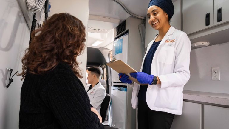  doctor of pharmacy student with patient in mobile clinic van