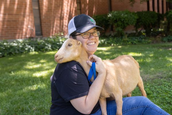 Associate Professor Melanie Felmlee sitting with a goat.