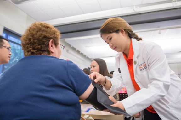 Student checking patient's blood pressure