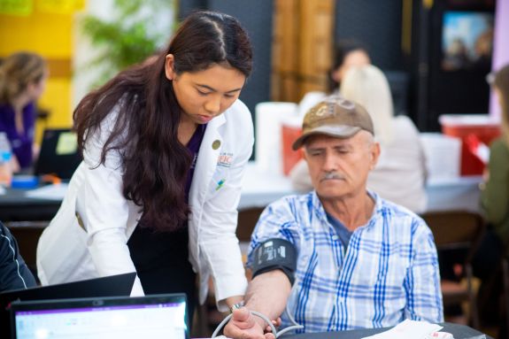 Student taking patient's blood pressure.
