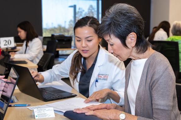 Pharmacy student and patient looking at a document.