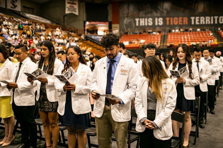 Students in White Coat Ceremony in Alex G. Spanos Center.