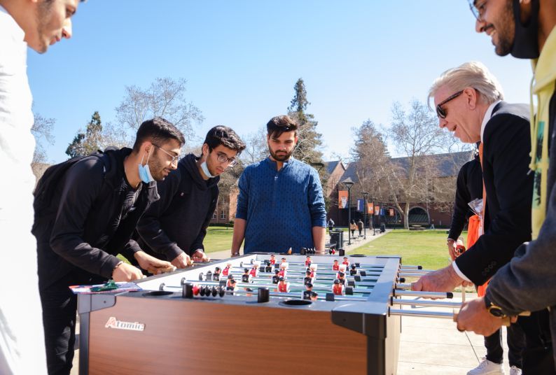 President Christopher Callahan plays foosball with students