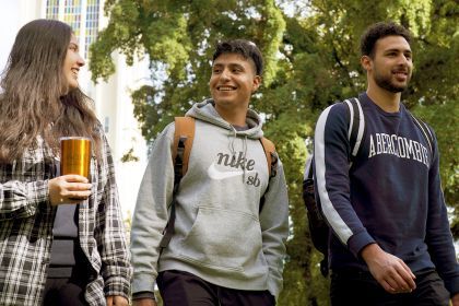 three students walk together on campus