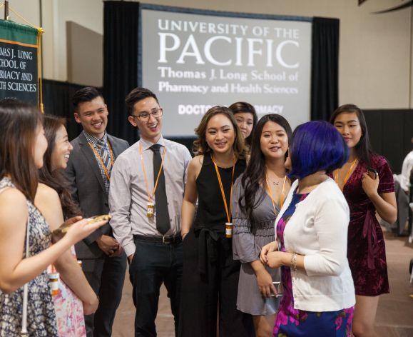 Group of PharmD graduates with a regional coordinator at the annual Pharmacy Graduation Banquet