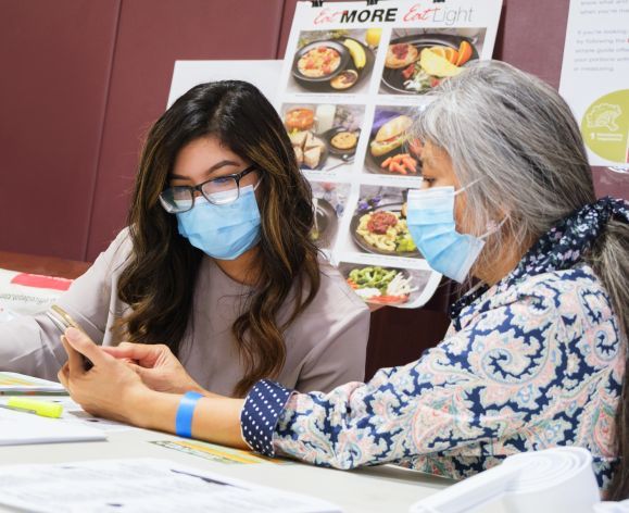 Pharmacy student with community member at health care outreach clinic